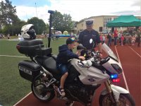 Policjant pokazuje dziecku motocykl służbowy.