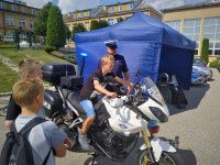 Policjant pokazuje dzieciom służbowy motocykl.