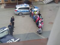 Policjanci z dziećmi na placu KPP.