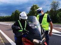 Policjant przeprowadza kontrolę drogową motocyklisty.
