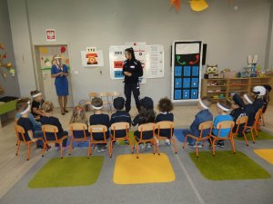 Policjantka rozmawia z przedszkolakami na temat zasad bezpieczeństwa.