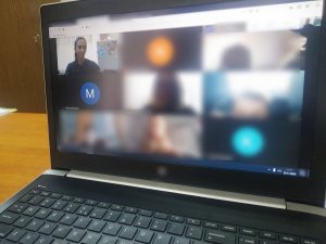 Zdjęcie laptopa, na którym widać połączenie online uczniów z policjantką.
