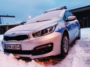 Radiowóz policyjny  w śnieżnej scenerii.