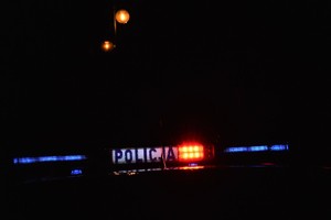 Zdjęcie nocą - widoczny podświetlony napis POLICJA  na radiowozie.