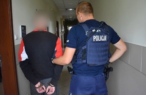 Policjant trzyma zatrzymanego