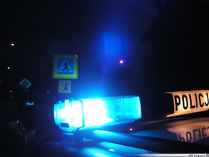 Policyjny radiowóz z włączonymi światłami.