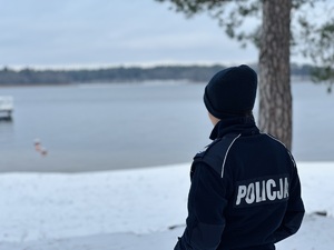 Policjantka stoi nad jeziorem.