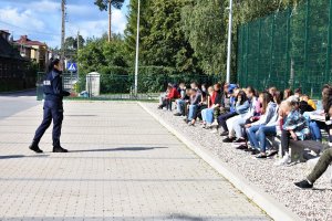 Policjantka rozmawia z uczniami na temat bezpiecznych zachowań na drodze.