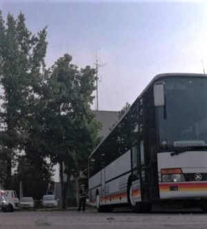 policjantka dokonuje kontroli autobusu, 
sprawdza stan techniczny pojazdu, gaśnicę, bieżnik na oponach