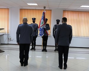 komendant zdający obowiązki komendanta oraz komendant przyjmujący obowiązki stoją na przeciwko pocztu sztandarowego jednostki