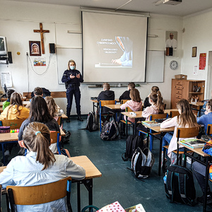 policjantka w sali lekcyjnej prowadzi spotkanie profilaktyczne z młodzieżą dotyczące bezpieczeństwa w sieci
