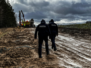 policjanci idą po pasie granicznym gdzie rozpoczęło się przygotowanie budowy zapory