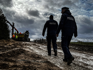 policjanci  idą po pasie granicznym gdzie rozpoczęło się przygotowanie budowy zapory