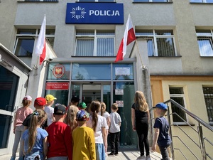 grupa przedszkolaków stoi przed wejściem do komendy