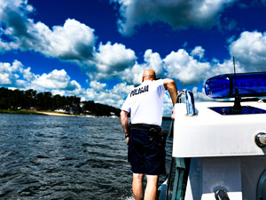 policjant stoi na łodzi