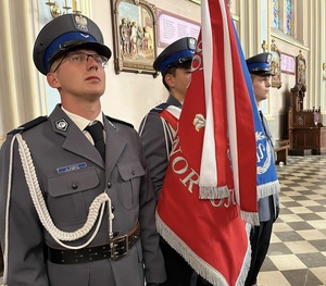 policjanci pocztu sztandarowego stoją w kościele ze sztandarem