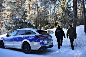 Policjanci wchodzą do lasu.