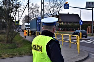 Policjant w rejonie przejścia dla pieszych nadzoruje pracę stopka.