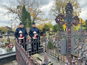 Policjanci trzymają znicze.