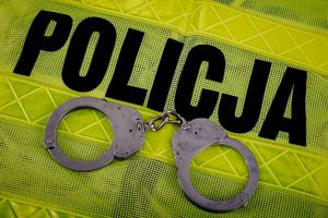 kamizelka z napisem policja a na niej leżące kajdanki