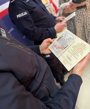 policjant trzyma podziękowanie w ręku