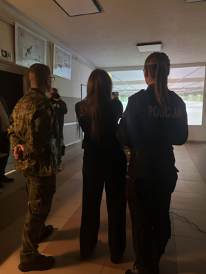 uczennica z policjantką i strażnikiem granicznym strzelają na strzelnicy laserowej