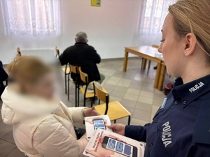 policjantka przekazuje kobiecie ulotke