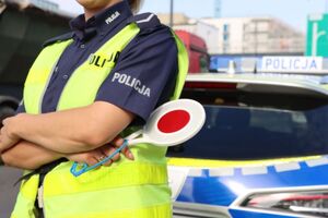 policjant stojący przed radiowozem