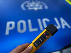 alkomat na tle radiowozu z pozytywnym wynikiem na zawartość alkoholu