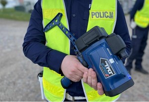 policjant trzymający ręczny miernik prędkości