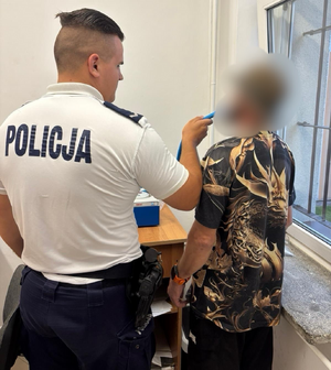 policjant bada na zawartość alkoholu mężczyznę