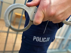 policjant trzymający w ręku kajdanki