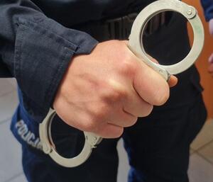policjant trzymający kajdanki